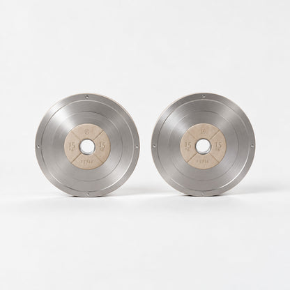 Klom Weight Plates Pair — front view; Grey Ash wood, beige leather and natural stainless steel where applicable. FYSIK studio finish study — October 2026. Representative configuration.