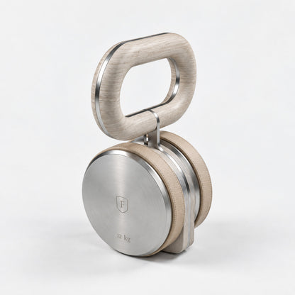 Kraba Individual Kettlebell — angled view; Grey Ash wood, beige leather and natural stainless steel where applicable. FYSIK studio finish study — October 2026. Representative configuration.