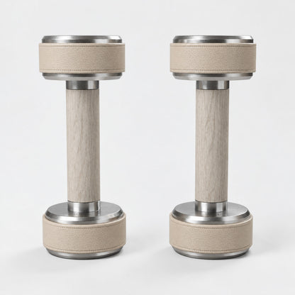 Nak Dumbbell Pair — front view; Grey Ash wood, beige leather and natural stainless steel where applicable. FYSIK studio finish study — October 2026. Representative configuration.